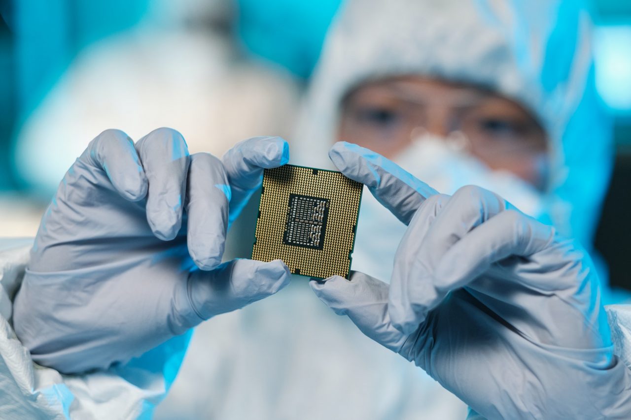 Gloved hands of contemporary scientist holding microchip