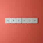 Free Close-up of keyboard keys spelling 'BACKUP' placed on a coral-colored surface. Stock Photo